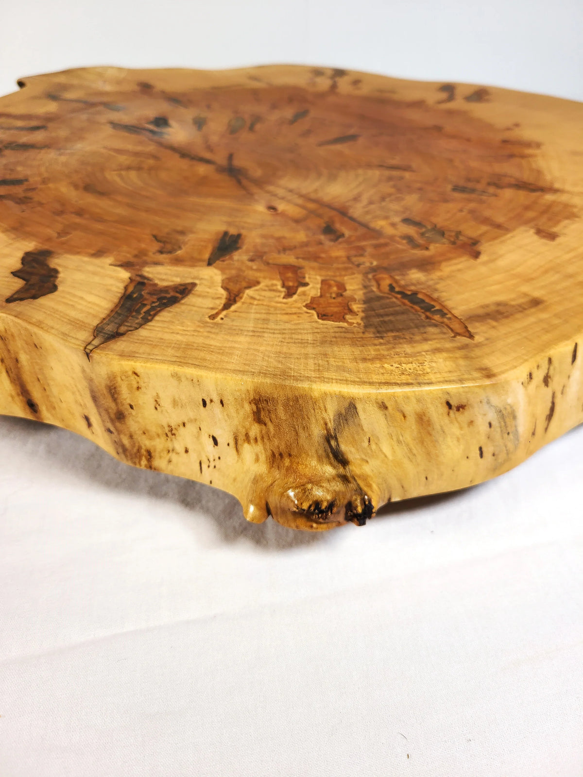 Wooden cutting board with natural edge on a white background