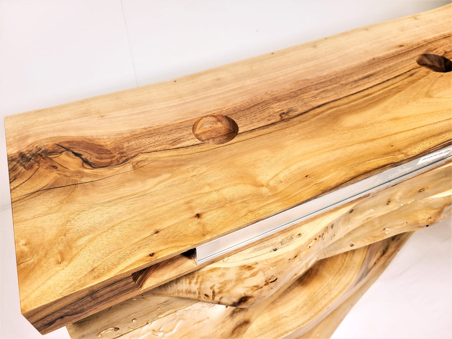 detail of bracket installed in the back of a floating shelf drilled for lighting