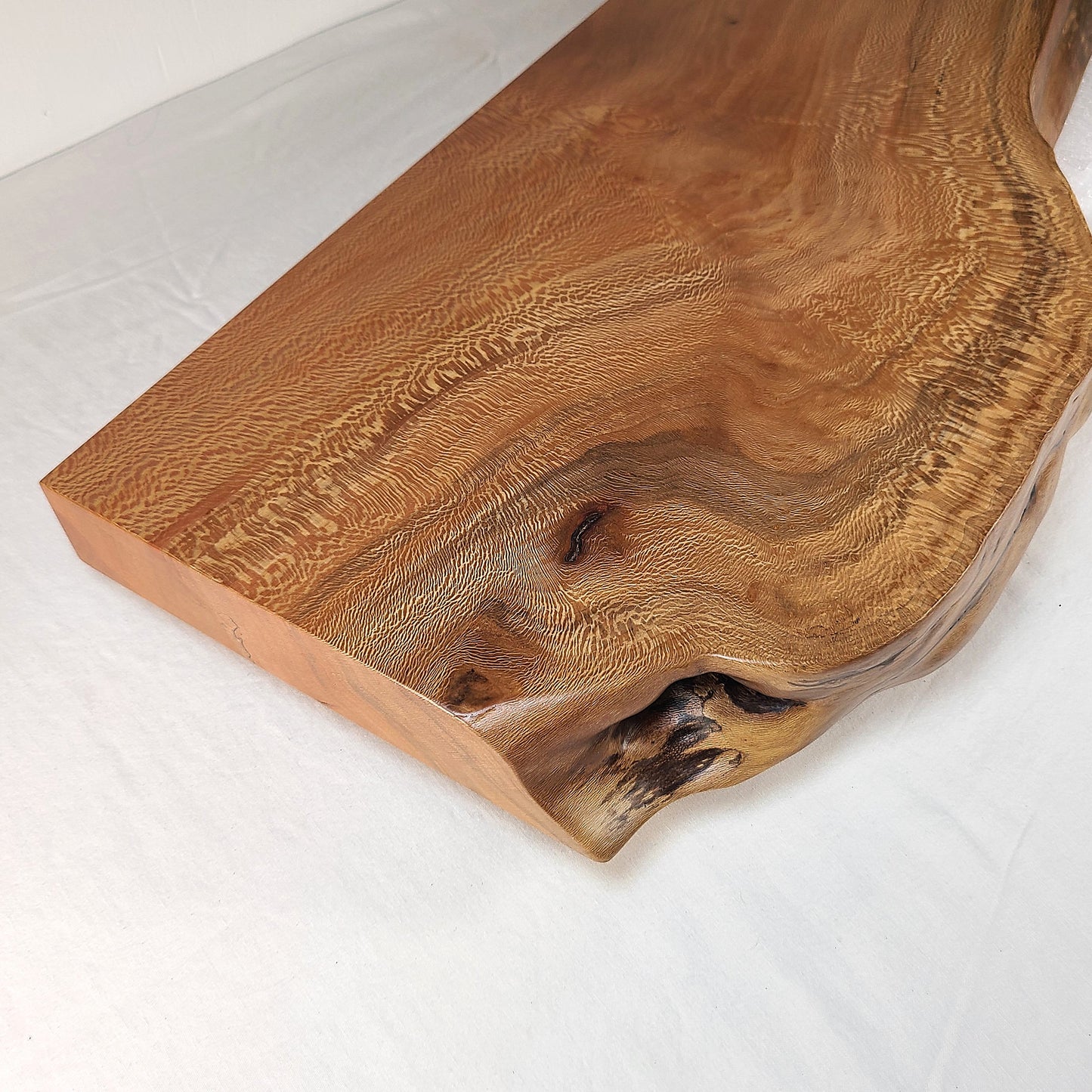 close up image of the grain pattern and color variations of a live edge floating shelf