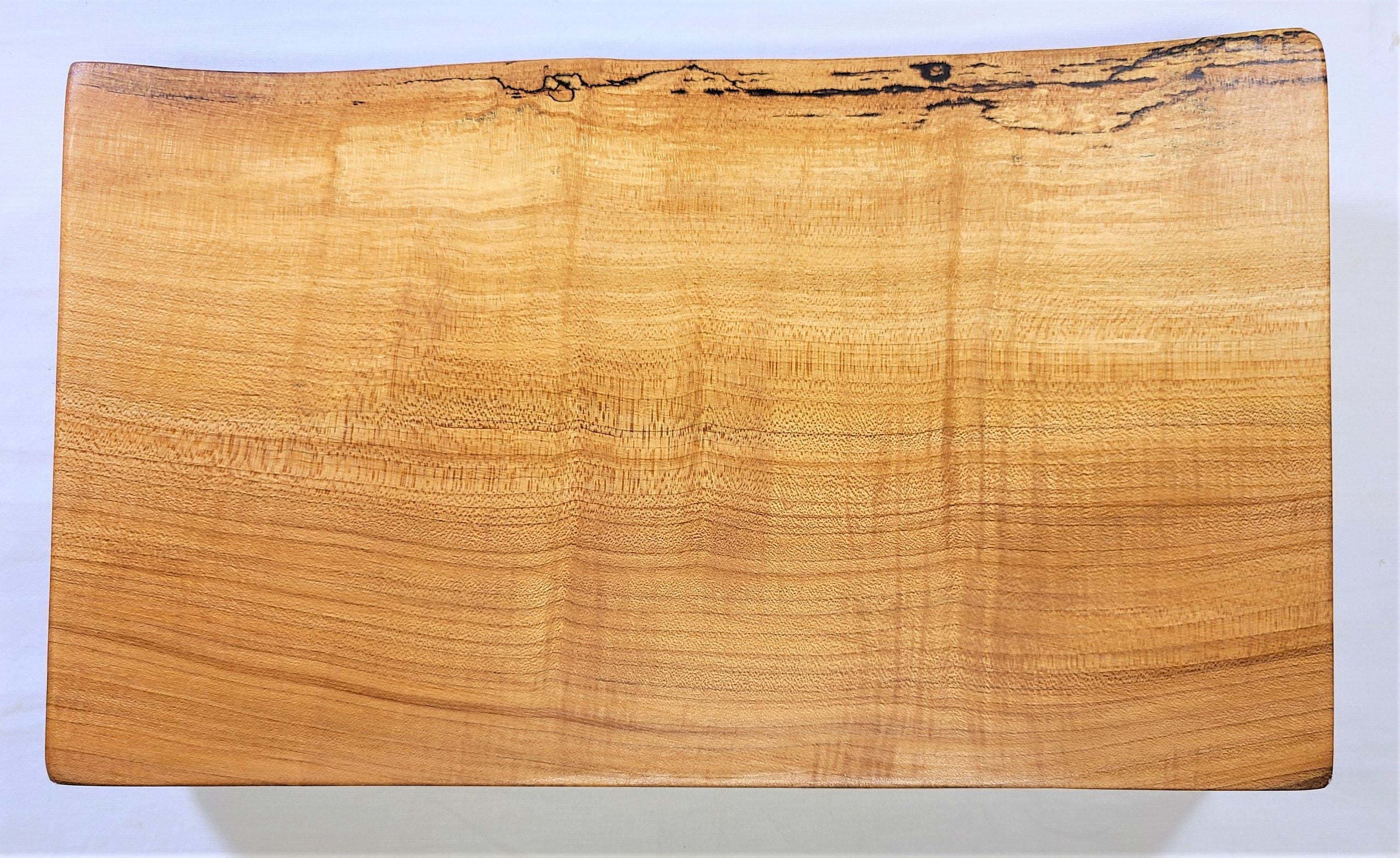 Maple cutting board made from a thick single solid piece of wood and features a live edge.  This maple cutting board can easily handle everyday slicing and dicing then turn it over and use it as a serving board for serving or charcuterie.  Made in USA by ZIMboards