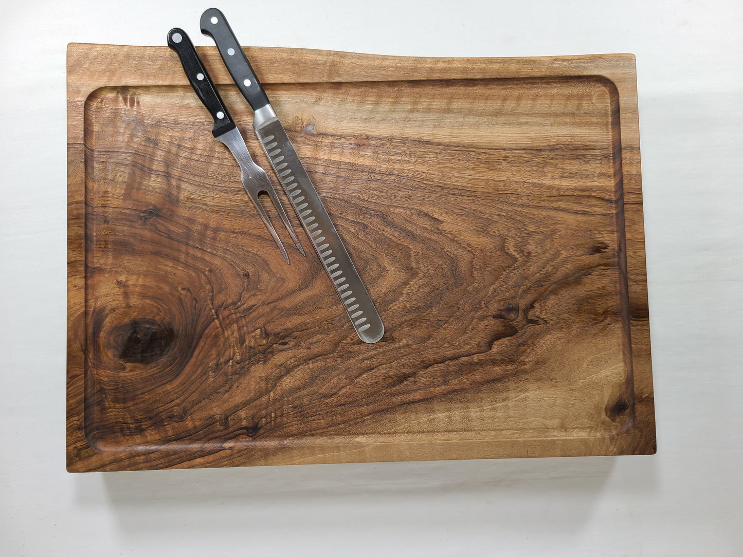 Custom english walnut live edge Carving Board featuring a well instead of a standard drip channel