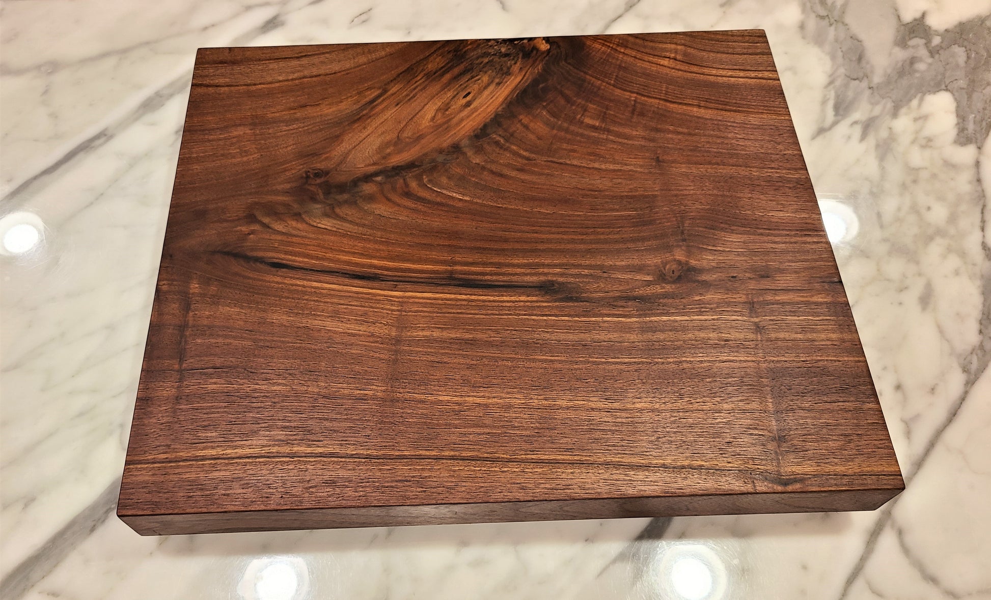 walnut cutting board with a flat cutting surface used to cut up fruits and vegetables rich deep color 