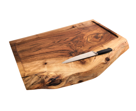 Custom cutting board made of one thick solid piece of walnut featuring a live edge