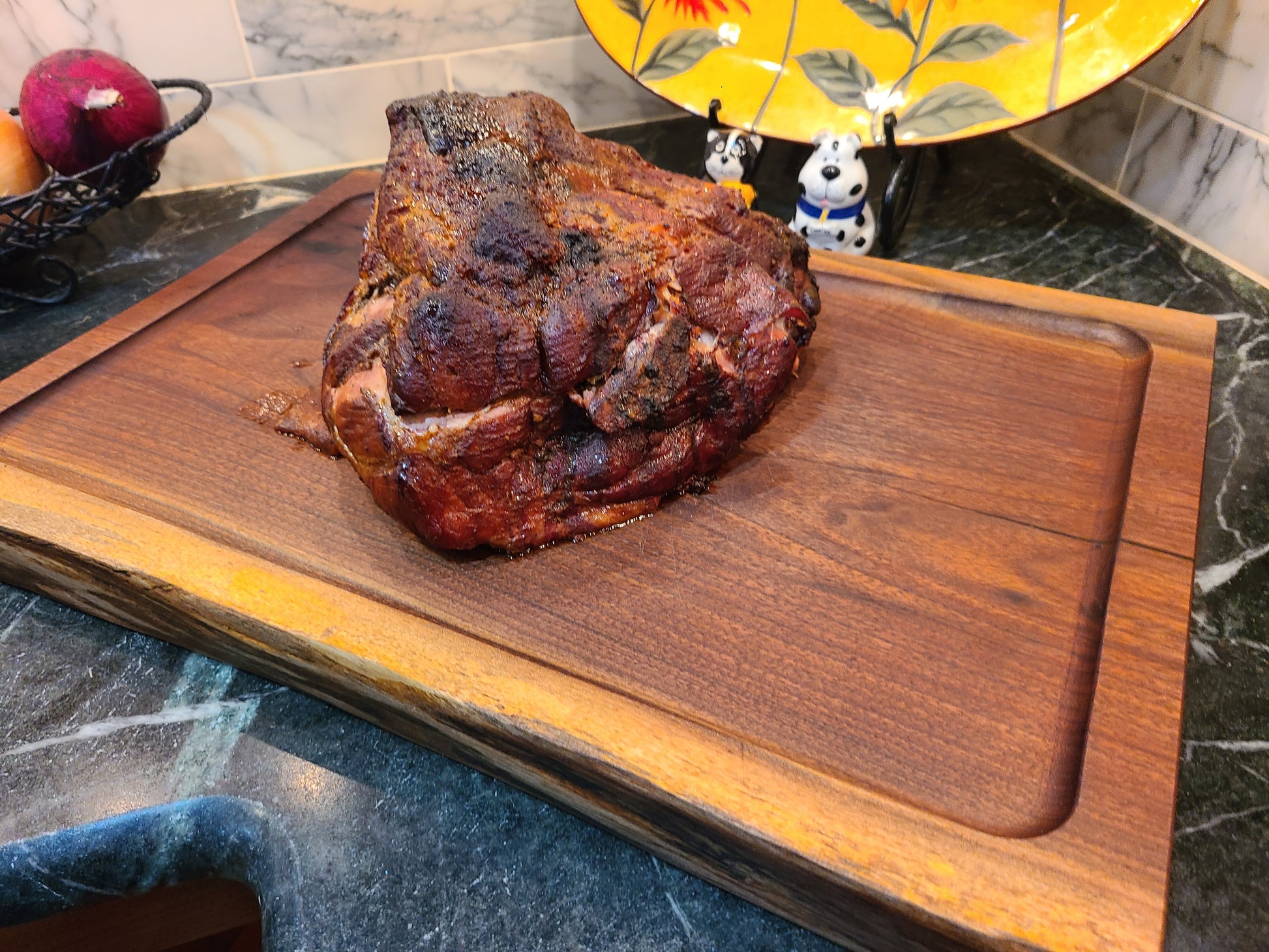 Roasted meat on a wooden cutting board with decorative elements in the background