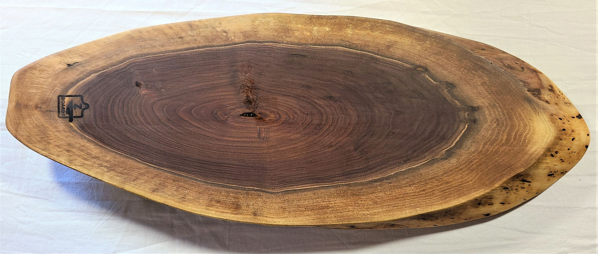 Wood charcuterie board is made of walnut with the unique oval shape.  Dark walnut center with lighter edge.  Made in USA  