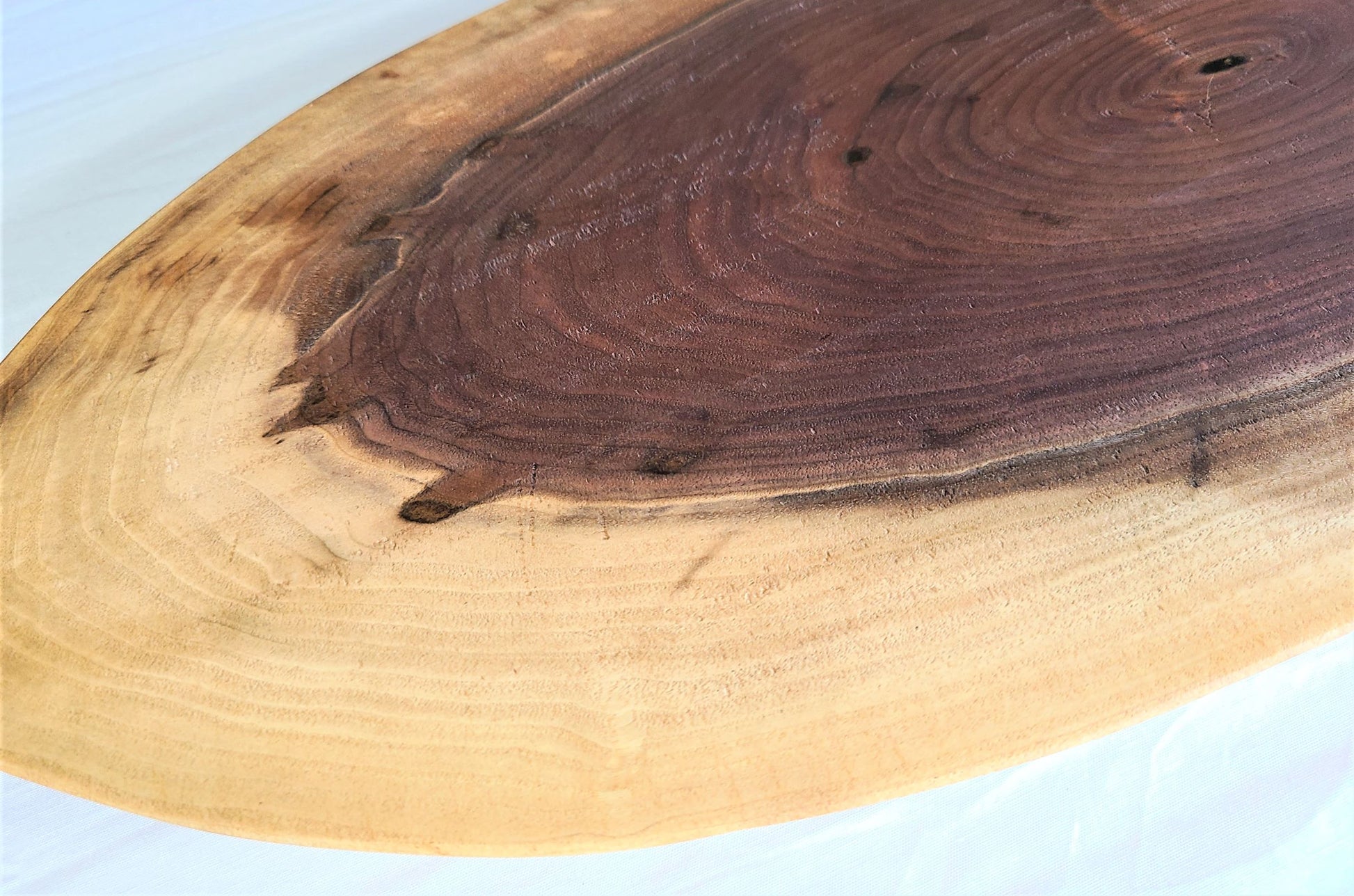 Wood charcuterie board made of walnut with the unique oval shape and live edge has an elegant look.  Made in USA 