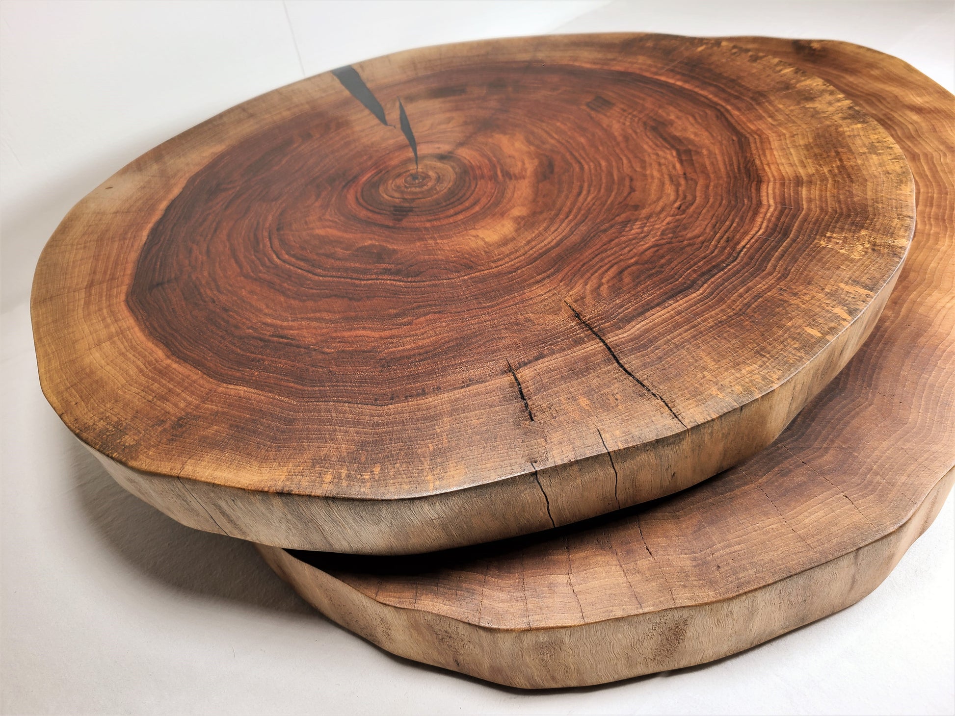 two different sizes of a round charcuterie board that can be used as a wood cake stand