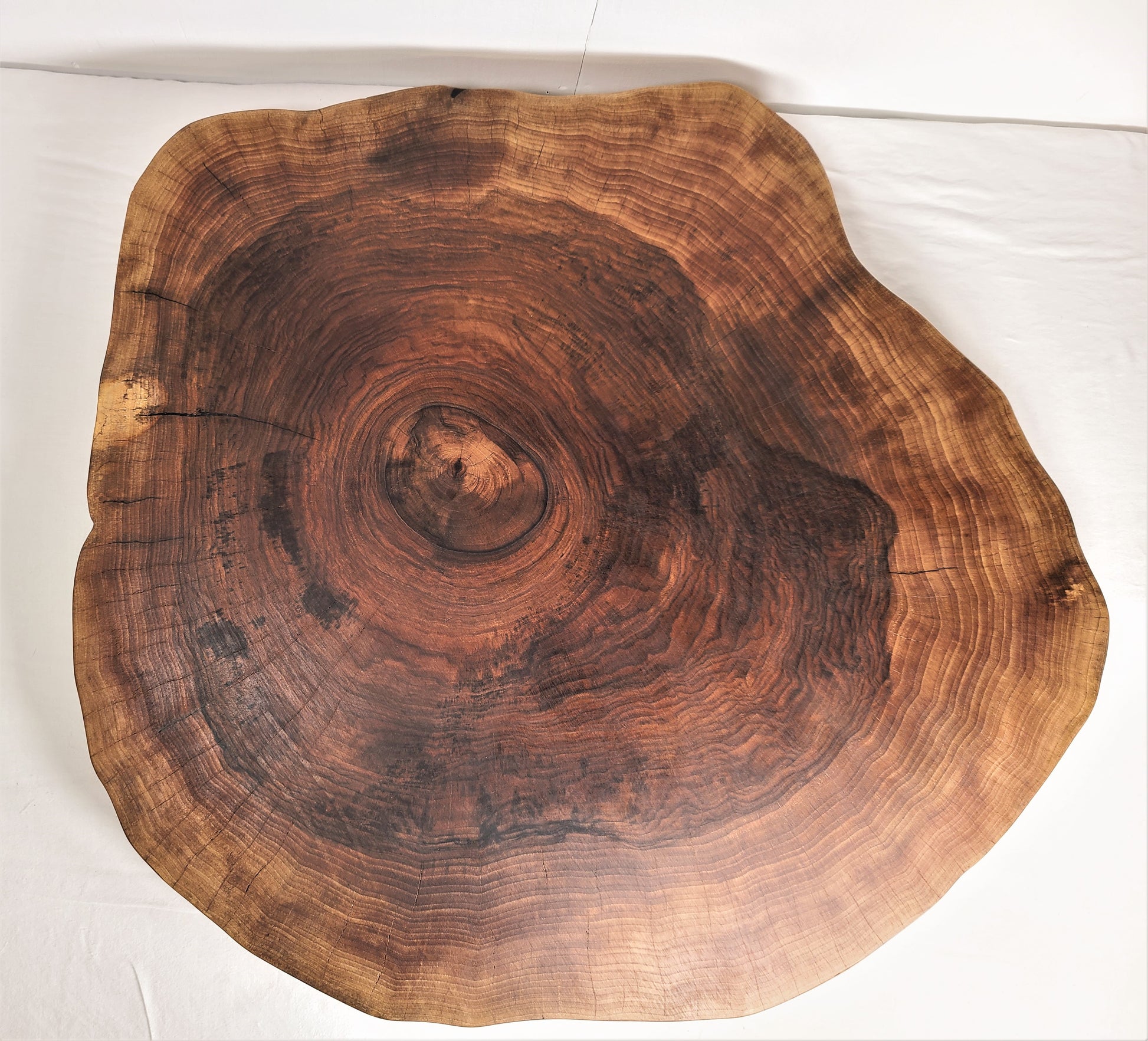 Custom wood cake stand made of live edge walnut features organic round shape