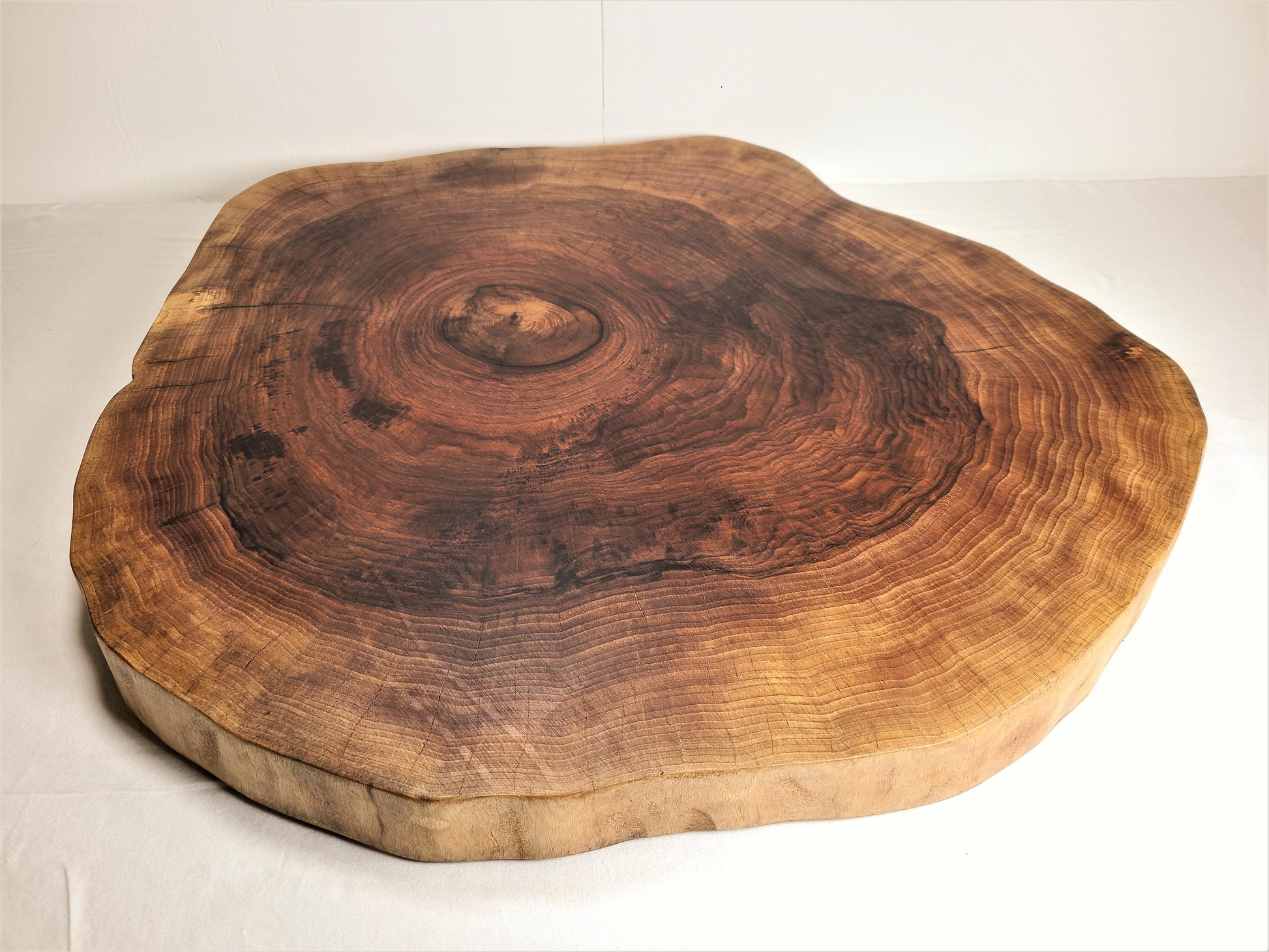 round cutting or charcuterie board.  suitable for a cake stand.  Made of a thick piece of round walnut.