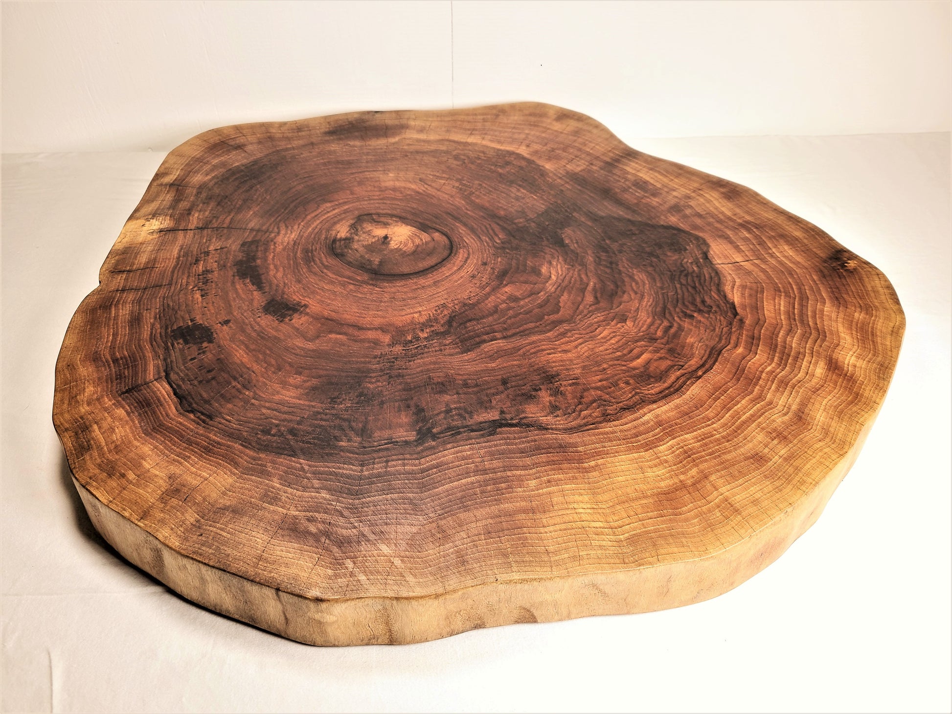 live edge cutting board made of thick round walnut 