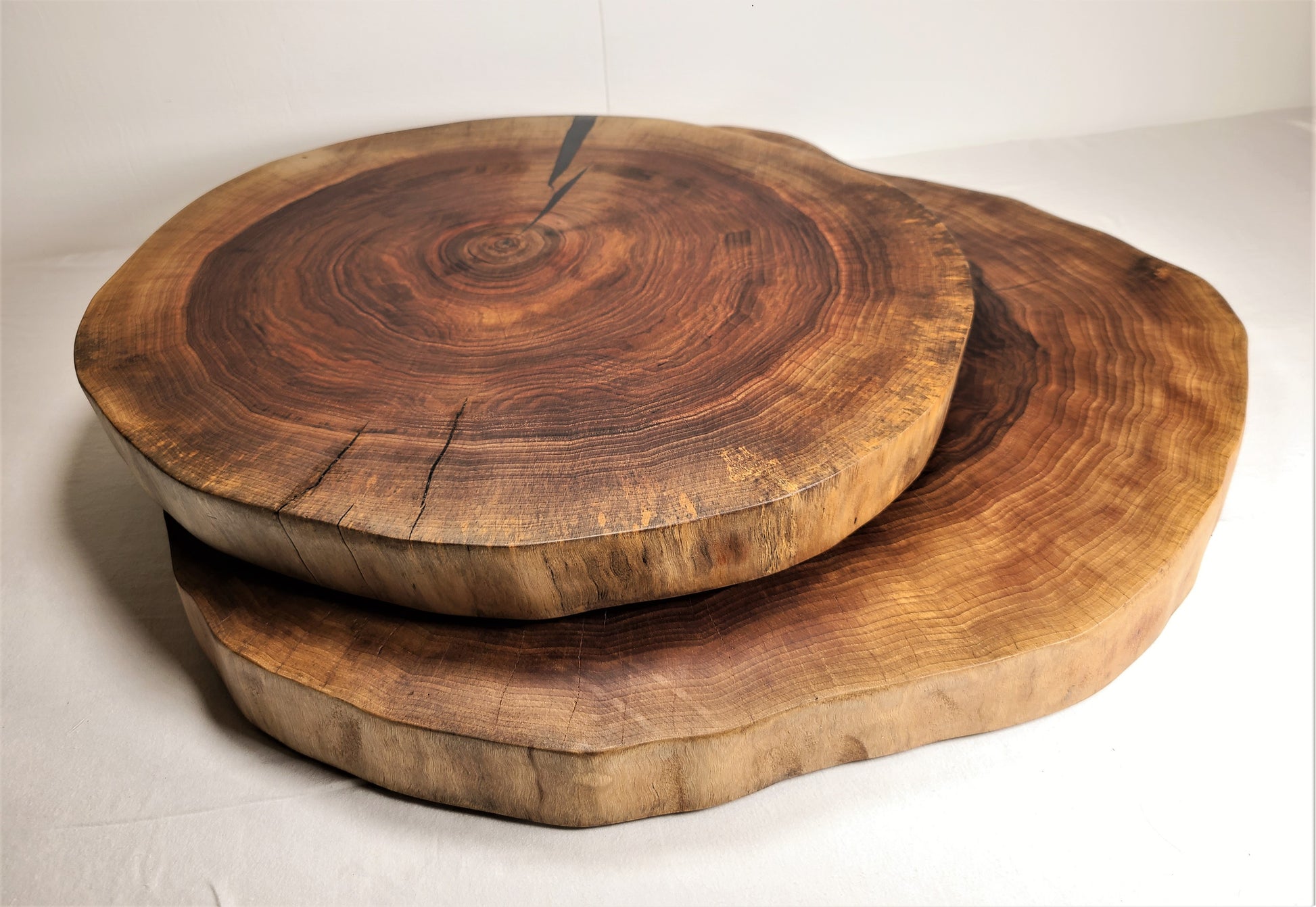 two live edge walnut wood cake stand in two different sizes.  Also can be used as a large charcuterie board or carving board.