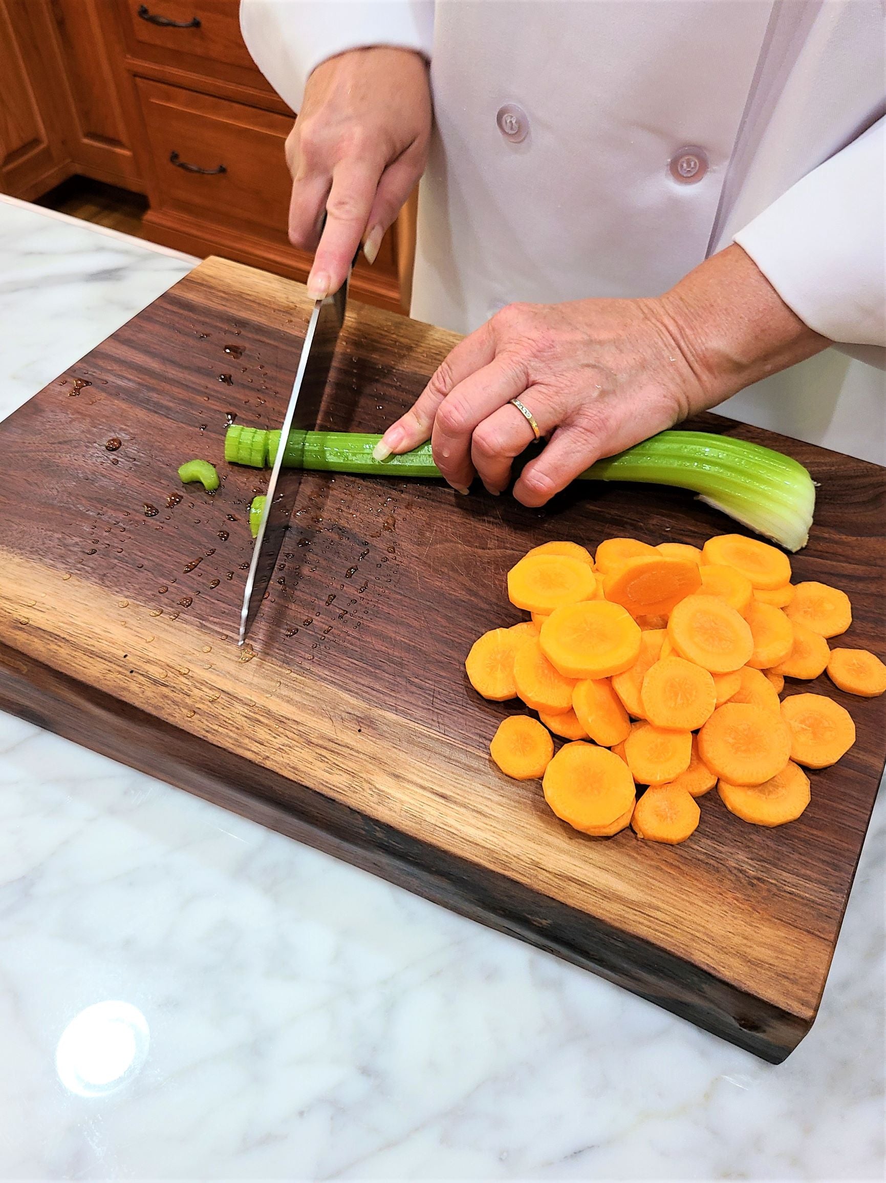 walnut carving board being used to slice carrots and celery walnut butcher block