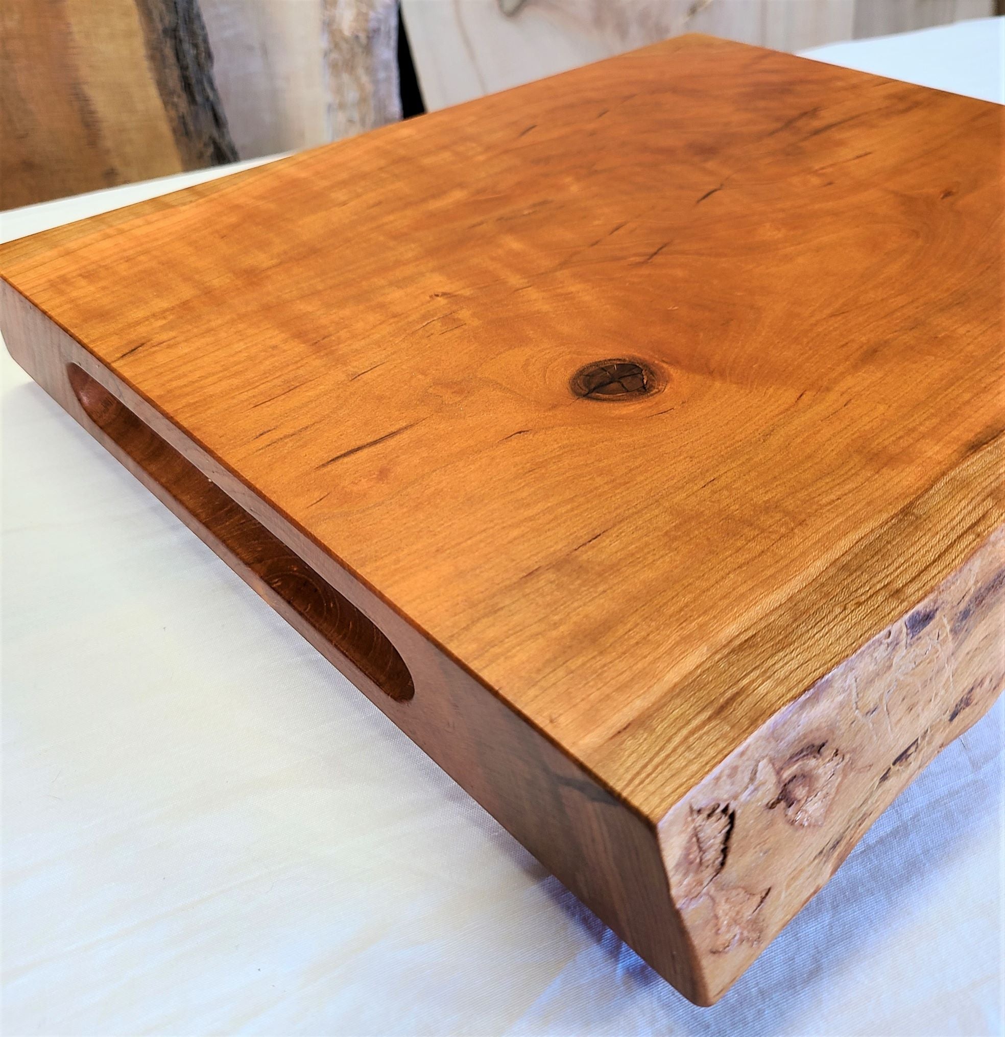 2" thick Cherry Cutting Board with routed finger grooves and features a live edge.  This custom cutting board is made in USA by ZimBoards.