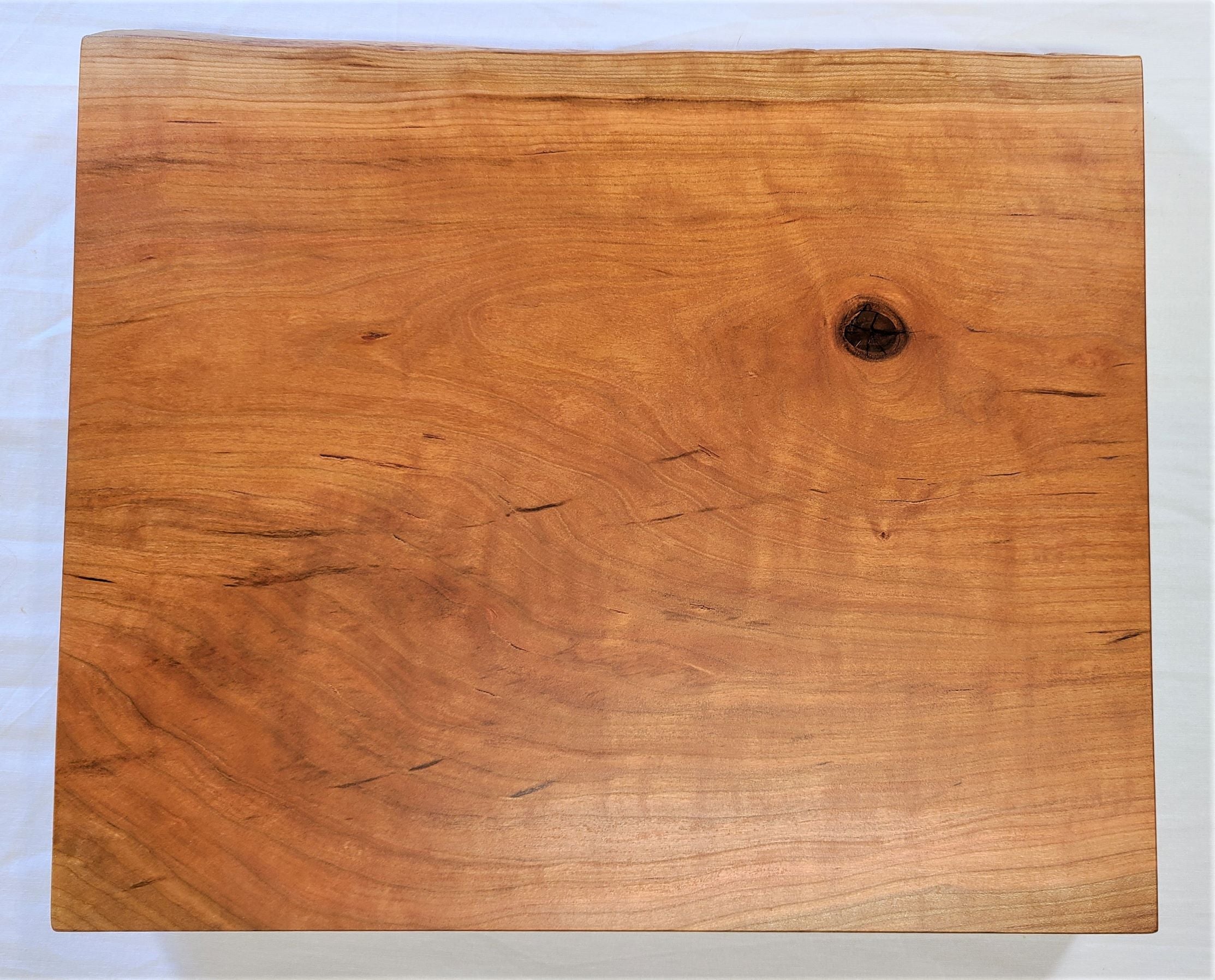 top view of a high end 2" thick custom cutting board made of cherry.  Features a live edge and routed finger holds.  Made in USA by ZimBoards.