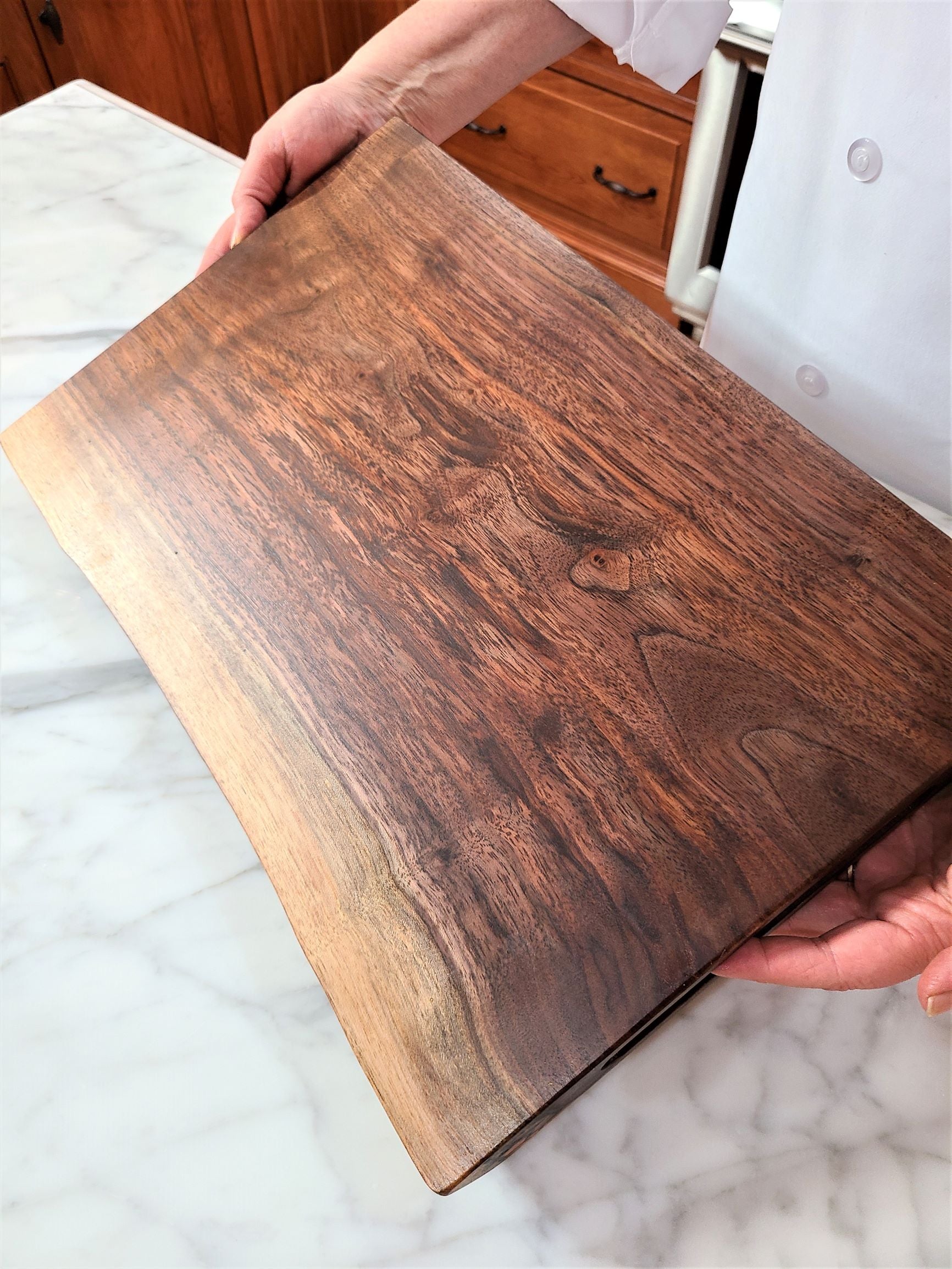 Large cutting board made from a thick solid piece of walnut.  IT features a live edge.  Custom cutting board made in USA by ZIM boards