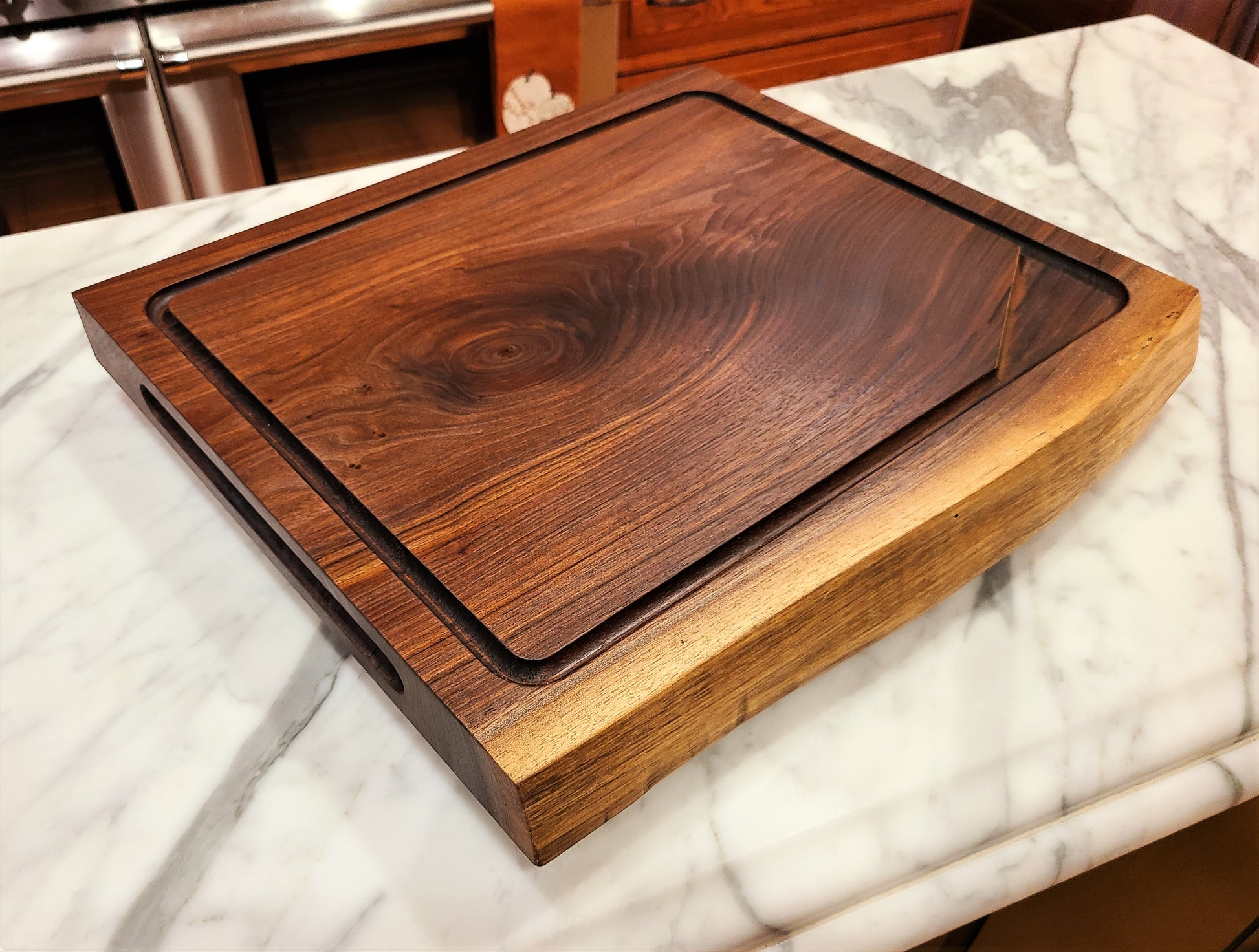 Meat cutting Board made of Walnut that features a drip edge with well to catch juice and a live edge.  