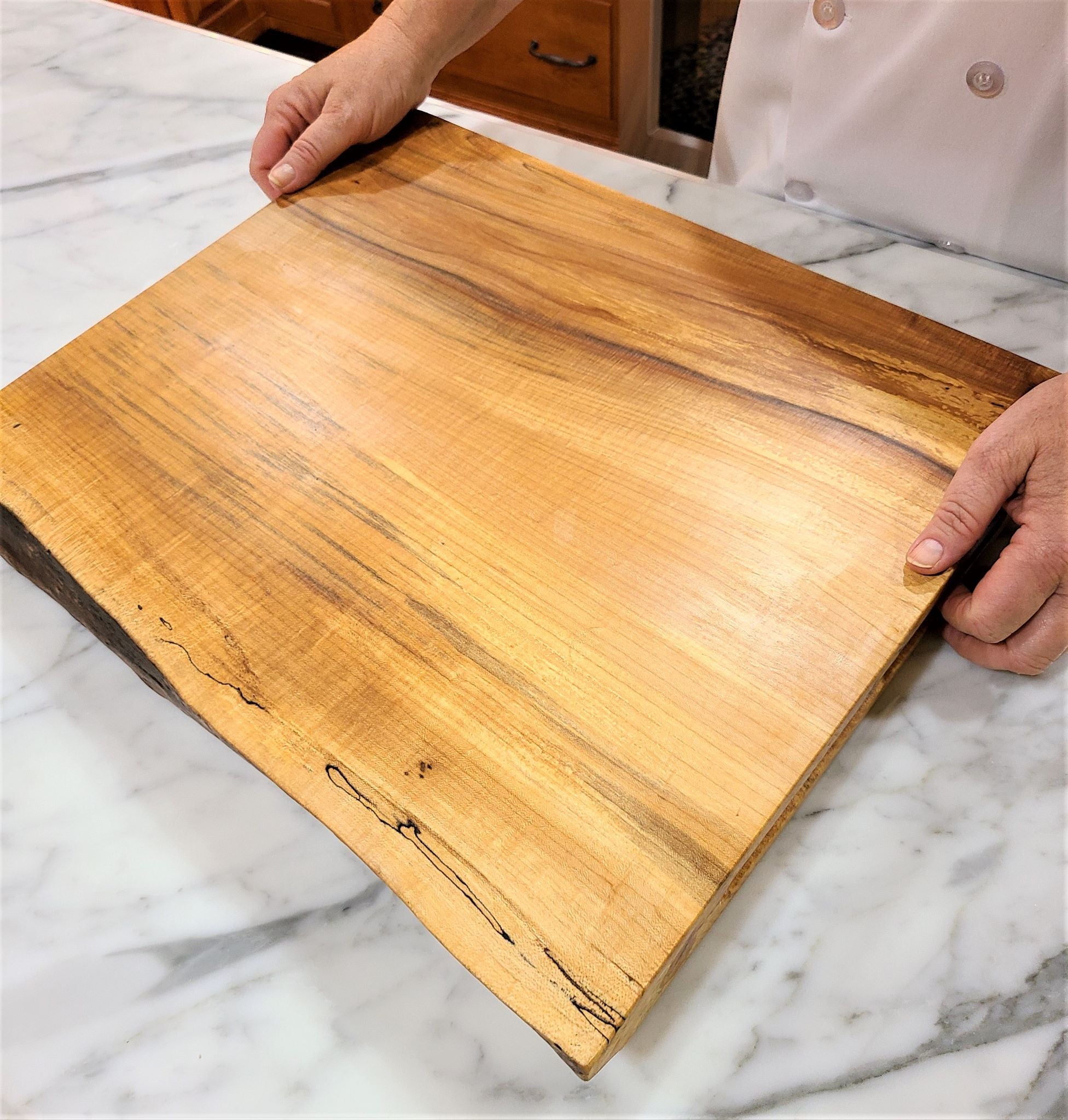 Large cutting board made of a solid thick piece of maple.  Live edge  charcuterie on one side and the other side is for carving.  Made in USA by ZIM boards.